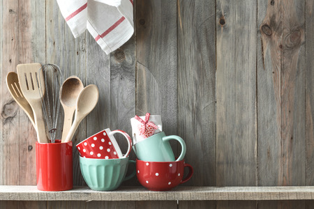 47181133 - kitchen cooking utensils in ceramic storage pot on a shelf on a rustic wooden wall, space for text